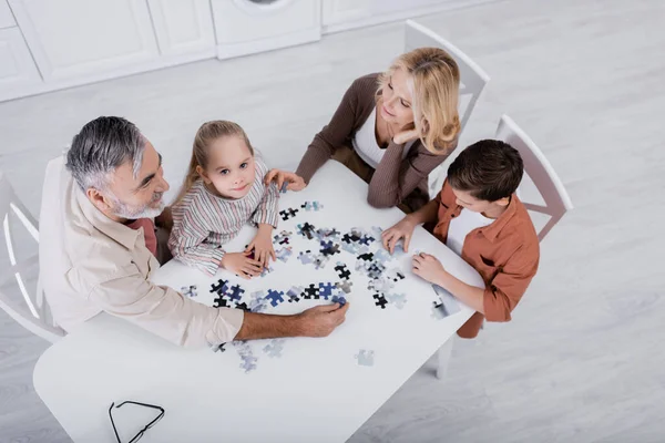Overhead View Girl Looking Camera While Playing Jigsaw Game Grandparents — Stock Photo, Image