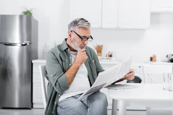 Eftertänksam Senior Man Glasögon Läser Morgontidningen Köket — Stockfoto