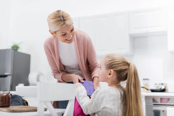 Fröhliche Frau Hält Lunchbox Neben Enkelin Und Glas Mit Schokoladenpaste — Stockfoto