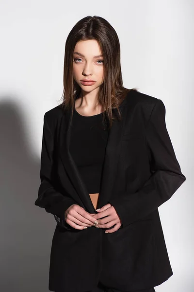 Young Woman Black Top Suit Looking Camera Grey Shadow — Stock Photo, Image