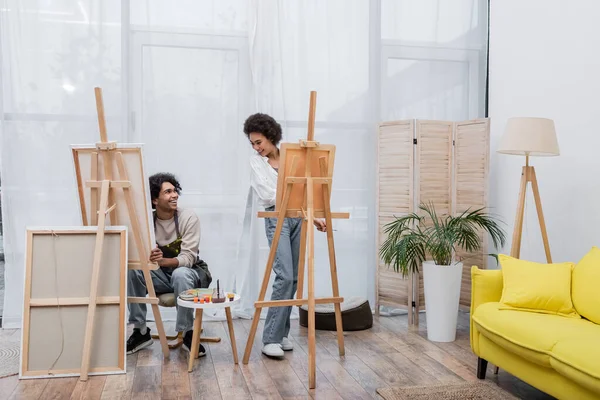 Positive African American Couple Looking Each Other While Painting Canvases — Stock Photo, Image