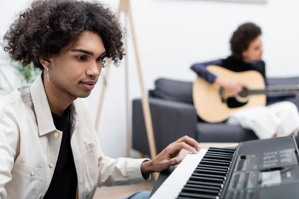 Joven Afroamericano Hombre Jugando Sintetizador Cerca Borrosa Novia Con Guitarra — Foto de Stock