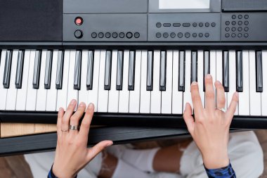 Top view of african american woman playing synthesizer at home  clipart