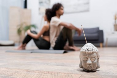 Bulanık Afrika kökenli Amerikalı bir çiftin oturma odasında meditasyon yaptığı tütsü çubuğu. 