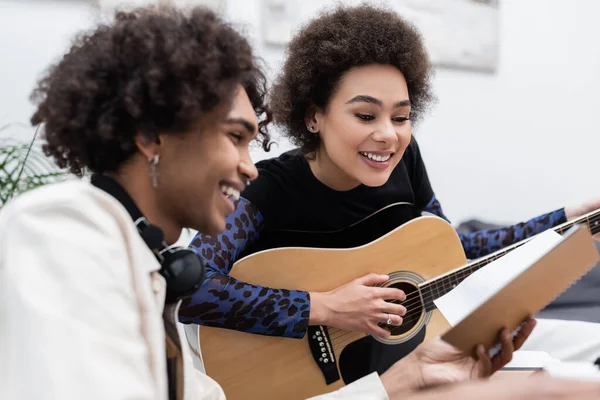 Giovane Uomo Afroamericano Possesso Notebook Vicino Fidanzata Suonare Chitarra Acustica — Foto Stock