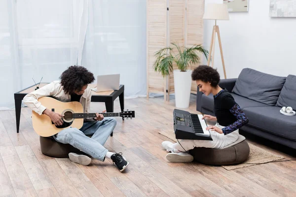 Couple Afro Américain Souriant Jouant Guitare Acoustique Synthétiseur Dans Salon — Photo