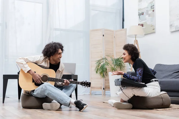 Alegre Mujer Afroamericana Con Sintetizador Hablando Con Novio Con Guitarra — Foto de Stock