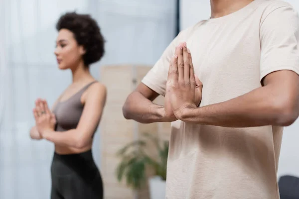 Afrikansk Amerikansk Man Praktiserar Yoga Nära Suddig Flickvän Hemma — Stockfoto