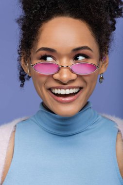 Menekşe üzerinde izole edilmiş pembe güneş gözlüklü Afro-Amerikan kadınına yakın çekim