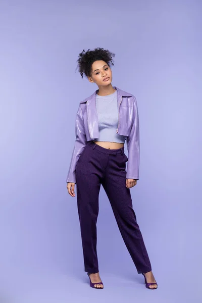 全长卷曲时髦的非洲女人 身穿紫罗兰色皮夹克和裤子 呈紫色 — 图库照片