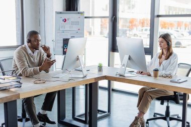 Modern ofiste çalışan, kulaklıklı ırklar arası operatörler.