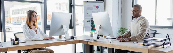 Colegas Interraciales Gafas Mirando Monitores Computadora Mientras Trabajan Oficina Moderna — Foto de Stock