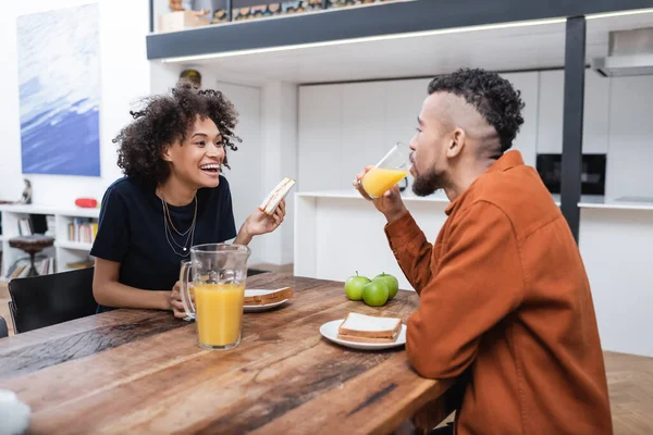 Cheerful African American Woman Holding Sandwich While Having Lunch Boyfriend — Stock Photo, Image