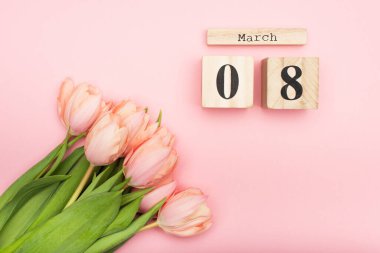 Tahta küplerin yanındaki lalelerin üst görüntüsü Pembe üzerine 8 yürüyüş 