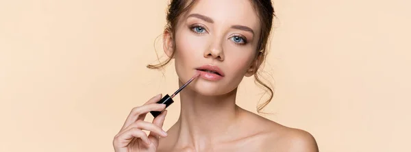 Pretty Young Model Applying Lip Gloss Isolated Beige Banner — Stock Photo, Image