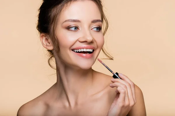 Positive Model Holding Brush Lip Gloss Looking Away Isolated Beige — Stock Photo, Image