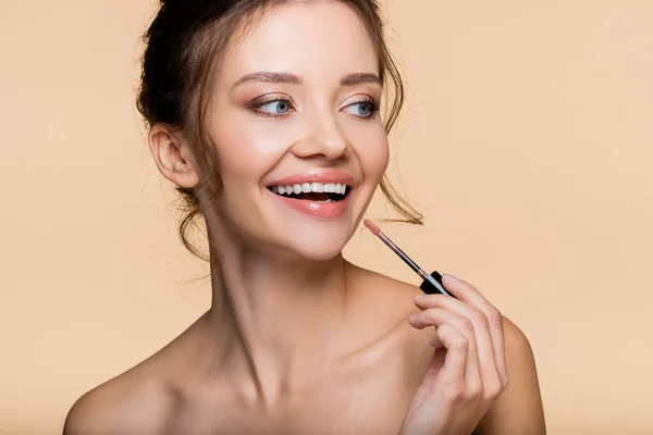 Positief Model Met Penseel Van Lipgloss Wegkijkend Geïsoleerd Beige — Stockfoto