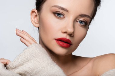 Kırmızı dudaklı şık modelin portresi beyaza izole edilmiş kameraya bakıyor