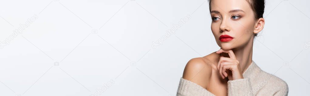 Pretty model with red lips holding finger near chin isolated on white, banner 