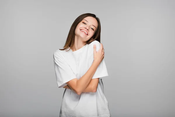 Zufriedene Frau Weißen Shirt Die Sich Isoliert Auf Grau Umarmt — Stockfoto