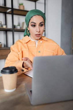 Şaşırdım. Mendilli Müslüman kadın kahvenin yanındaki bulanık laptopu gösterdi.