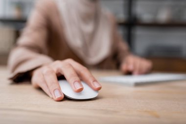 selective focus of computer mouse in hand of cropped woman working on blurred background clipart