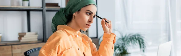 Mulher Muçulmana Pensativo Caneta Headkerchief Segurando Enquanto Estuda Casa Banner — Fotografia de Stock