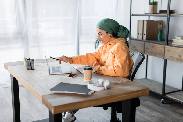 Donna Araba Sorridente Che Punta Computer Portatile Mentre Impara Casa — Foto Stock