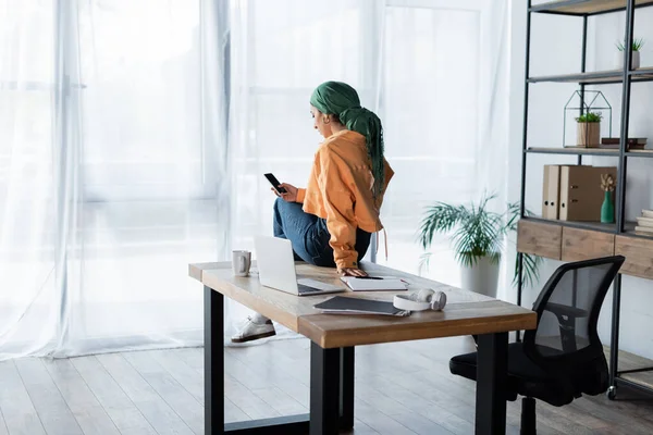 Muslimische Studentin Freizeitkleidung Mit Smartphone Schreibtisch Neben Laptop — Stockfoto
