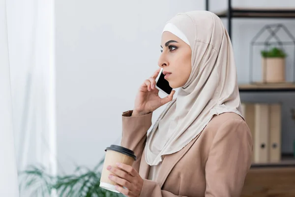 Boční Pohled Muslimské Ženy Mluví Smartphone Zatímco Stojí Kávou Jít — Stock fotografie