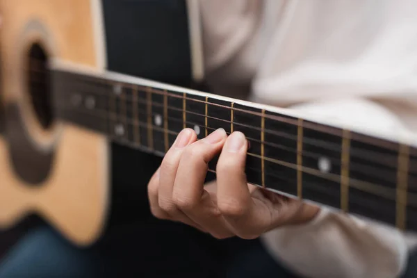 stock image partial view of woman playing acoustic guitar, blurred background