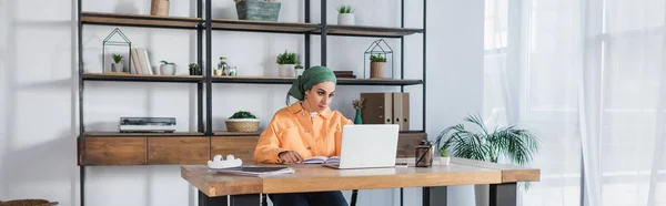 Junge Muslimische Frau Sitzt Neben Laptop Während Sie Modernen Wohnzimmer — Stockfoto