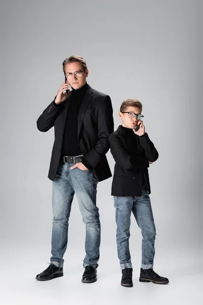 Full Length Father Son Talking Smartphones Grey Background — Stock Photo, Image