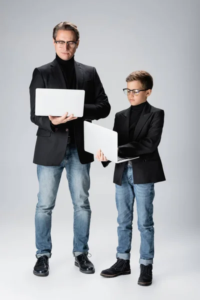 Πλήρες Μήκος Του Trendy Άνδρα Και Αγόρι Χρησιμοποιώντας Φορητούς Υπολογιστές — Φωτογραφία Αρχείου
