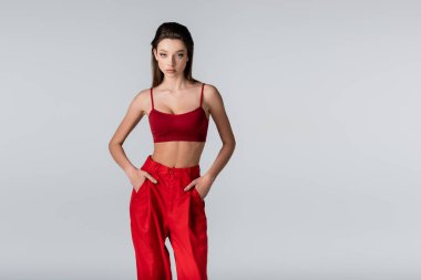 Gri cepli, kırmızı elbiseli genç bir model.