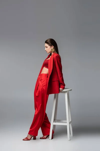 Full Length Young Woman Trendy Red Suit Standing White Chair — Stock Photo, Image