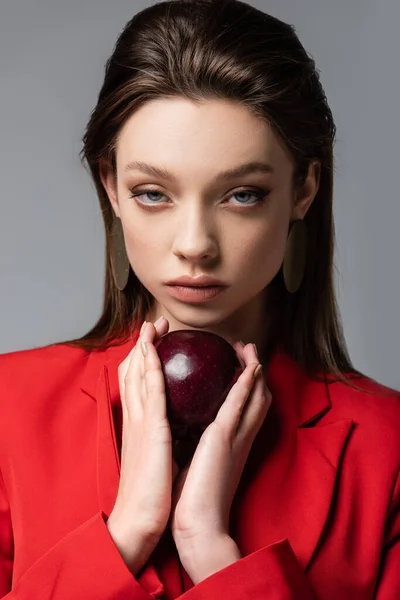 Mladá Žena Červeném Saku Náušnice Drží Jablko Izolované Šedé — Stock fotografie