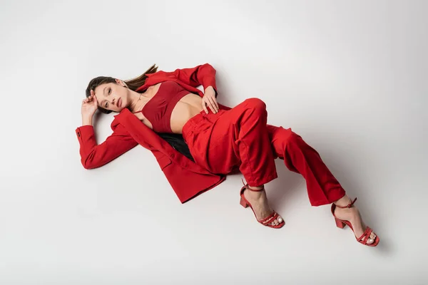 High Angle View Stylish Young Woman Red Outfit Lying Grey — Stock Photo, Image