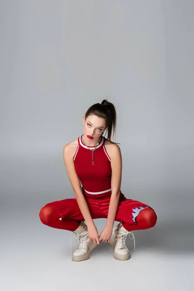 Full Length Young Woman Red Sportive Outfit Boots Sitting While — Stock Photo, Image