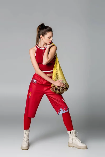 Full Length Της Trendy Γυναίκας Κόκκινο Σπορ Ντύσιμο Κρατώντας Κίτρινη — Φωτογραφία Αρχείου