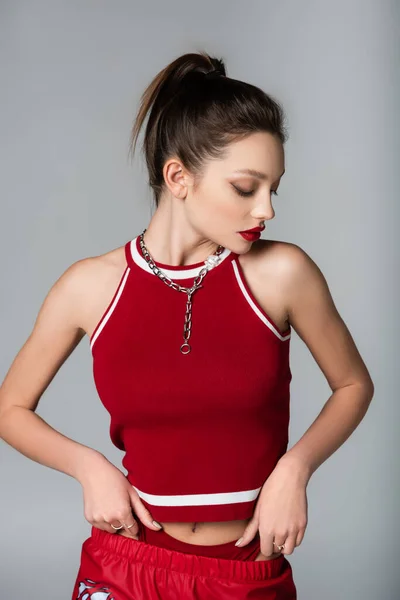Mladá Stylová Žena Červené Sportovní Oblečení Náhrdelník Řetěz Izolované Šedé — Stock fotografie