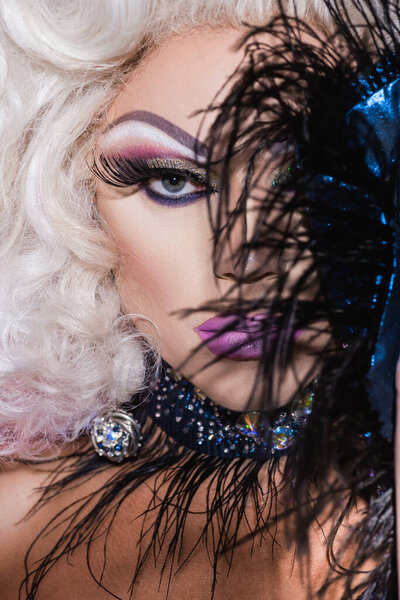 close up portrait of drag queen looking at camera on blurred foreground