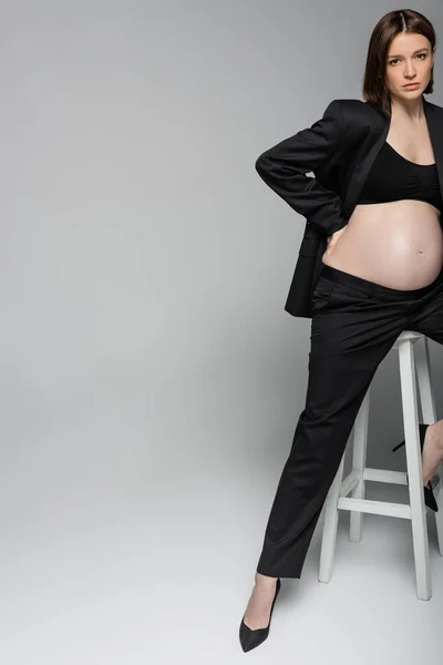 Jonge Zwangere Vrouw Pak Zitten Stoel Grijze Achtergrond — Stockfoto