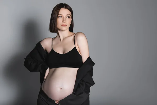 Gravid Kvinna Jacka Och Topp Vidrör Magen Grå Bakgrund — Stockfoto