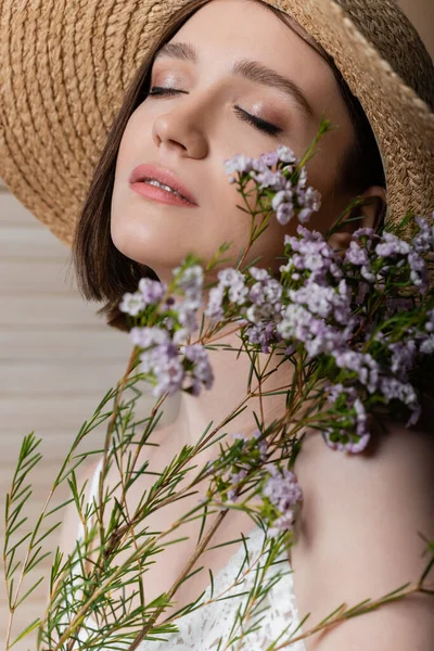 Portrét Ženy Slamáku Držící Rozmazané Rostliny Šedém Pozadí — Stock fotografie