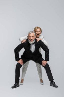 Olgun gelin, gri arka planda sakallı damadın yanında poz veriyor. 