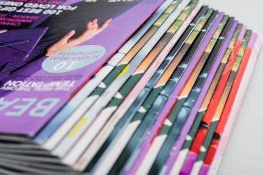 close up view of colorful magazines collection isolated on grey clipart