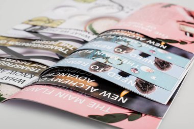 close up view of colorful magazines on grey background clipart