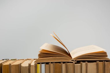 row of books with open one isolated on grey with copy space clipart