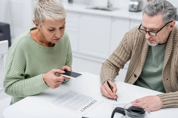 Elderly Woman Taking Photo Contract Husband Document Coffee Kitchen — Stock Photo, Image